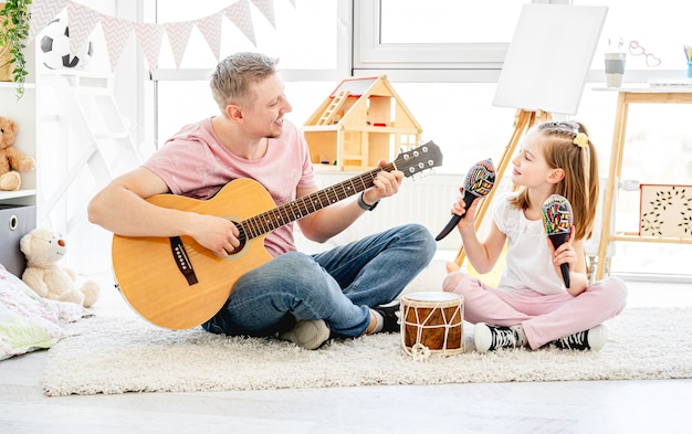 Father and daughter playing musical instruments