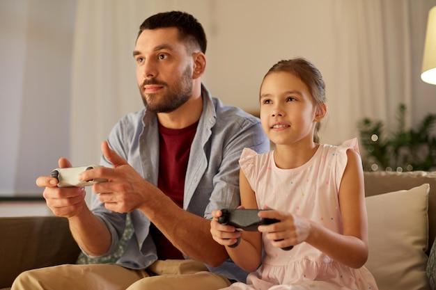 家でビデオゲームをしている父親と娘