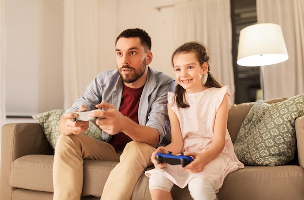 家でビデオゲームをしている父親と娘