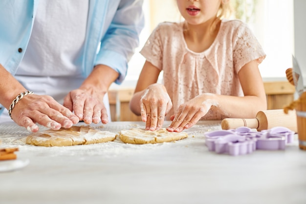 Father and daughter preparing dough together in kitchen, Family cooking at home, weekend concept
