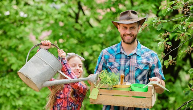 father and daughter on ranch little girl and happy man dad earth day spring village country ecology watering can and shovel family farm working in greenhouse florist at work