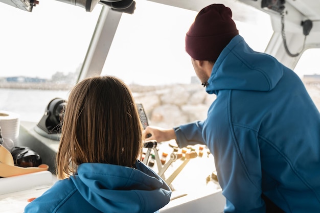 Father and daughter sailing boat in the sea inside boat family\
adventure and skipper concept