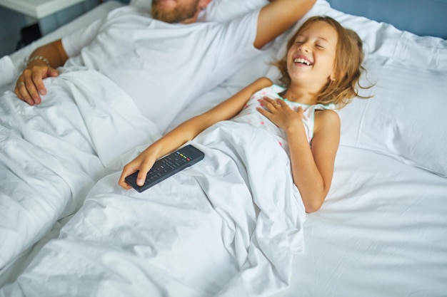 Foto padre e figlia dormono pacificamente insieme in una camera da letto luminosa durante