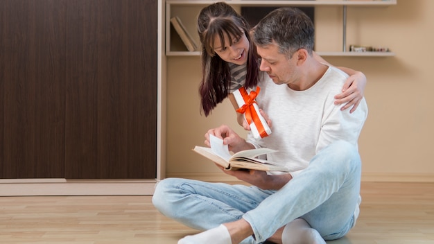 Photo father and daughter spending father's day indoors