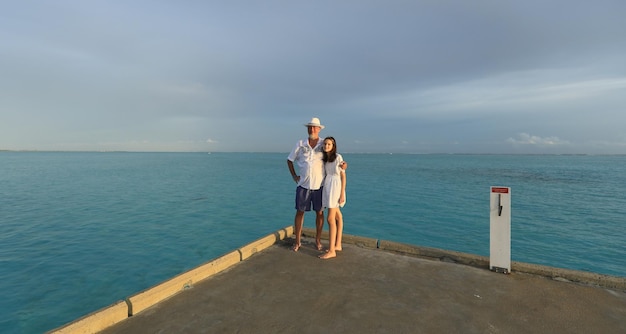 father and daughter taking pictures on the ocean