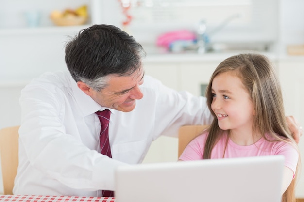 Father and daughter using laptop