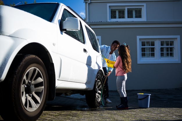 Photo father and daughter washing car together