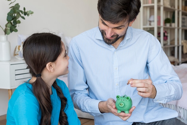father and daughter with piggy bank