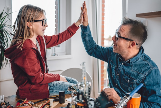 Father and daughter working on electronics components and cheering