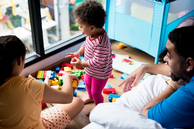 Photo father and daughters playing with building blocks