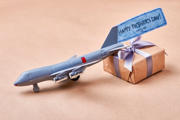 Father Day card and gift. Toy plane near present box. Cute gift in childish style.