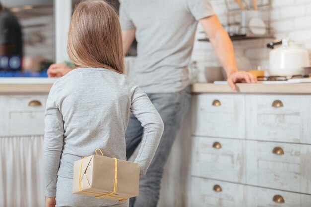 father day loving daughter prepared surprise gift for her dad hiding package behind back