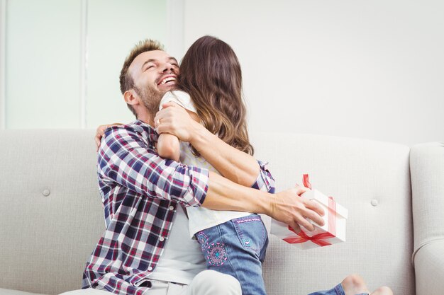 Father embracing his daughter and holding a gift