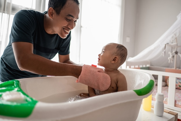 Father enjoy wash her baby boy