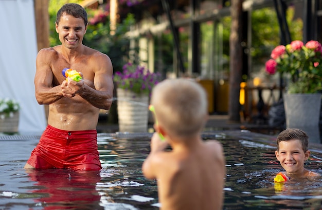 Foto padre che si gode una giornata con i suoi bambini in piscina