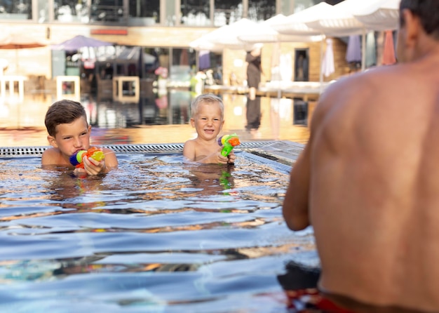 Foto padre che si gode una giornata con i suoi bambini in piscina