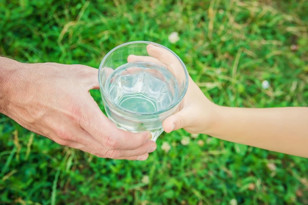 The father gives the child a glass of water Selective focus