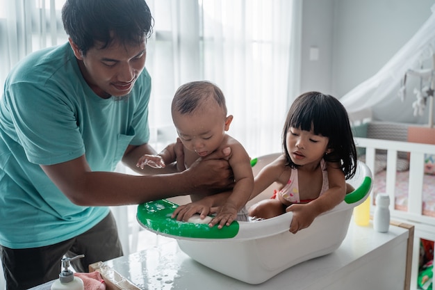 Father giving bath to his children