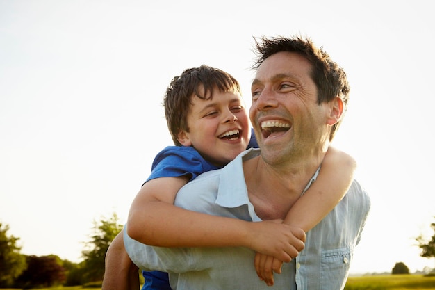 Foto un padre che accompagna suo figlio sulle spalle