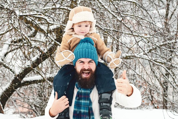 Father giving son ride on back in park