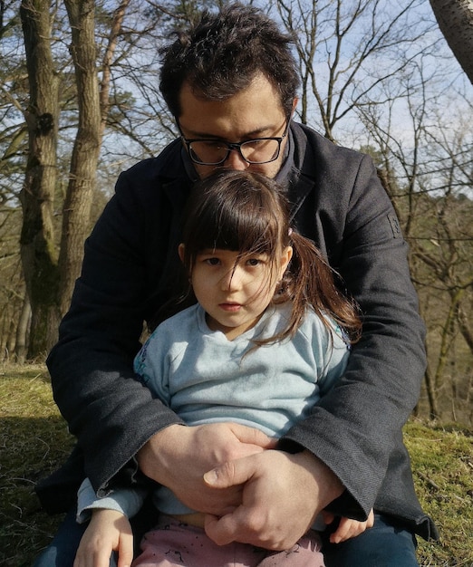 Photo father haging daughter sitting outdoors