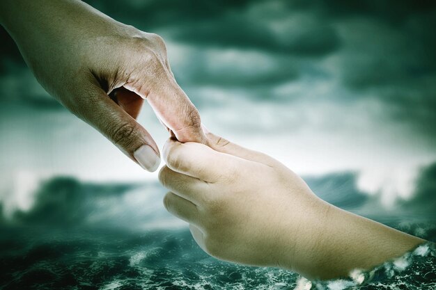 Photo father hands helps his son drown on overflow river