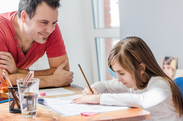 Photo father helping daughter with homework