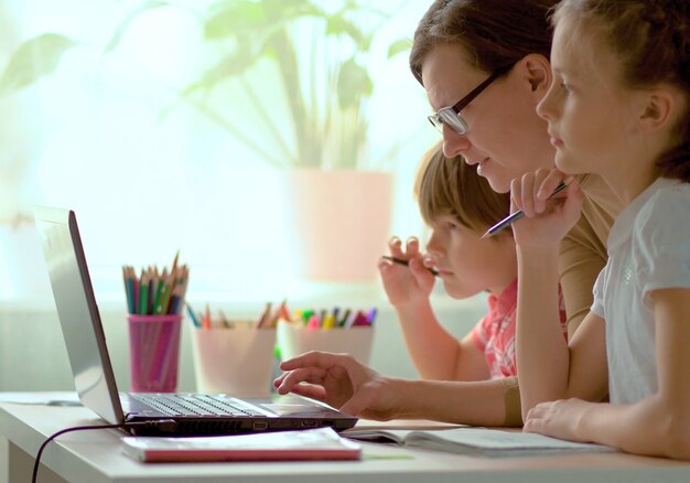 Photo father helping his kids to finish homework