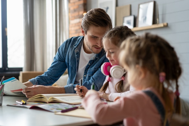 A father helping his little daughter to do her homework for the school.