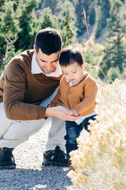 Foto padre che aiuta suo figlio a camminare