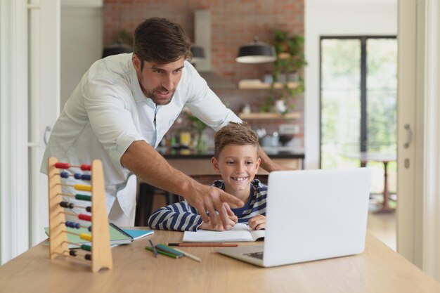 Photo father helping his son with homework in a comfortable home