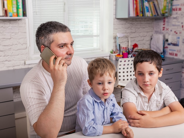 Father helping his sons at online homework