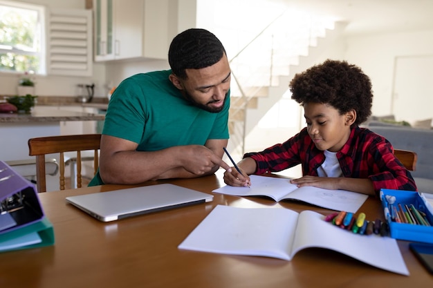 Father helping son with homework at home