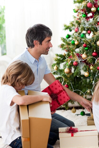 父と彼の少年がクリスマスプレゼントを開く