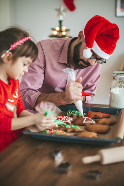 Father and his daughter decorating cookies