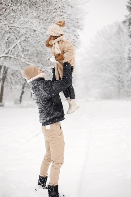 Father and his little daughter playing outdoors at winter day