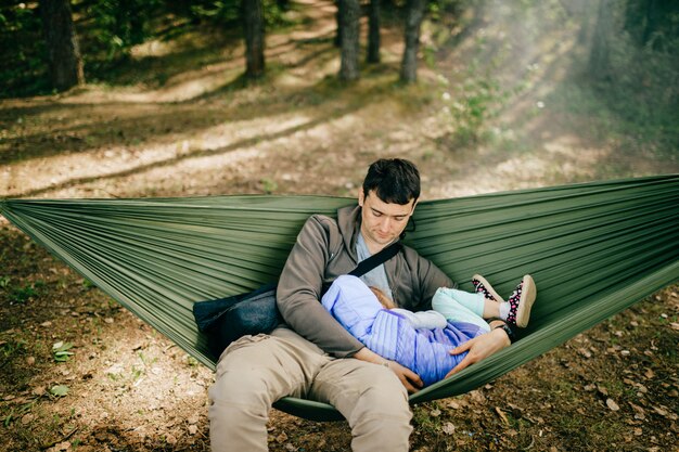 Father and his little daughter relaxing in hammock