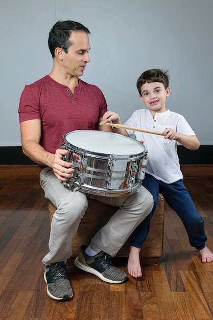 Photo father and his son with a drum and sticks