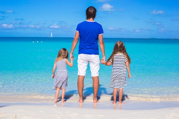 Father and his two kids walking by the sea