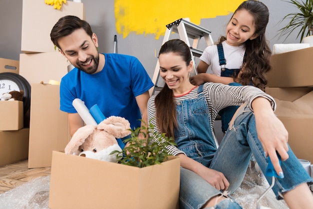 Father and his wife and daughter sort things out from boxes