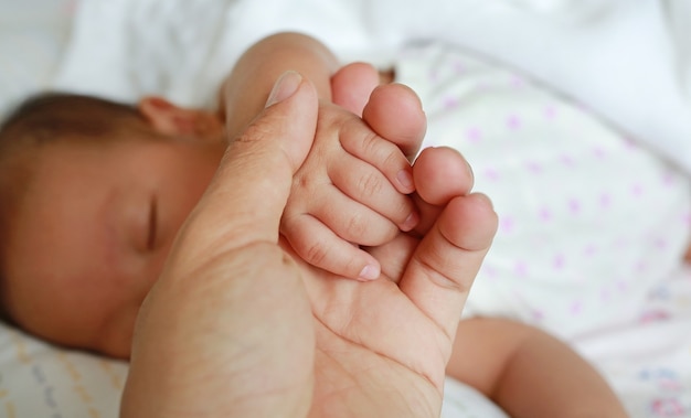 Father holding baby hand. Concept of love and family.