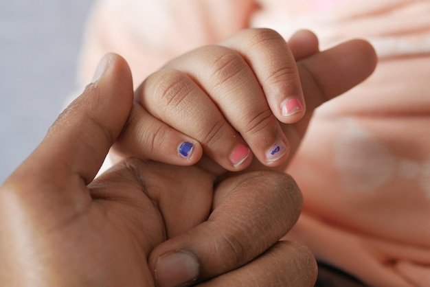 Father holding hand of baby child close up