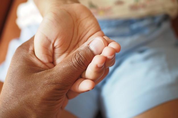 Father holding hand of baby child close up