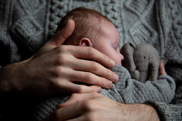 A father holding his baby son on his chest Family bonding Fatherhood