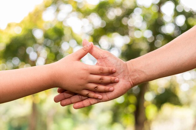 Father holding sons hand in a public garden