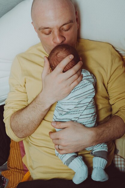 Photo father holds a baby in his arms