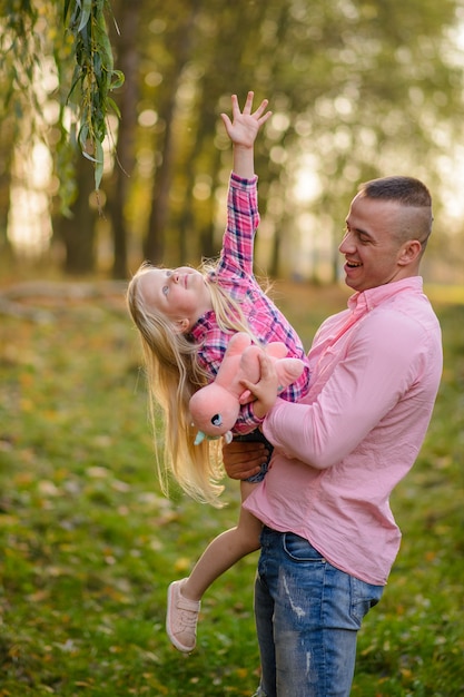 Father holds daughter in his arms.