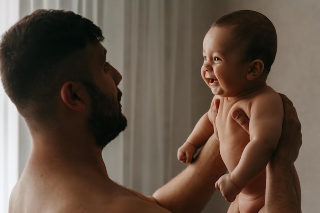 A father holds his baby in the bathroom.