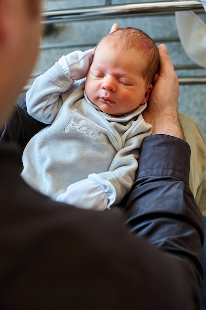 A father holds his newborn child in his arms