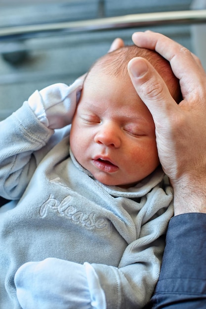 A father holds his newborn child in his arms